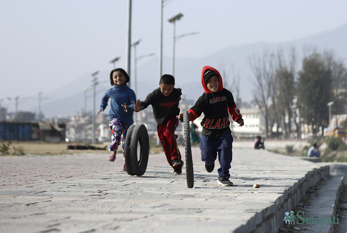 ललितपुरको कुपण्डोलमा पुराना साइकलको टायर गुडाएर खेल्दै गरेका बालबालिकाहरू।  तस्बिर : नवीनबाबु गुरुङ/सेतोपाटी